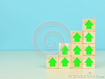 Wooden cubes with percentage and arrow icons stacking as stairs upward direction. Stock Photo