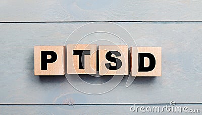 Wooden cubes with the text PTSD on a light blue wooden background Stock Photo