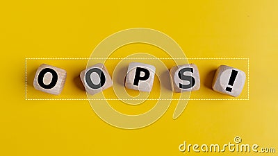 The wooden cubes with the word oops on a yellow background. Apologies for any mistake or error Stock Photo