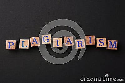 Wooden cubes with word Plagiarism on black background, flat lay Stock Photo