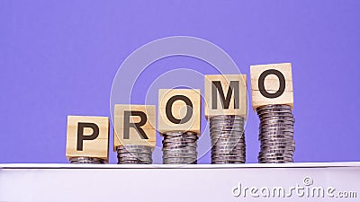 wooden cubes with the word Promo on money pile of coins, business concept Stock Photo