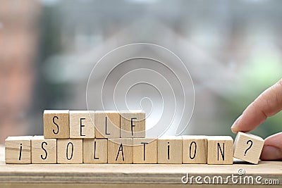 Wooden cubes with the word Self isolation and a question mark for Covid-19, coronavirus needs quarantine concept Stock Photo