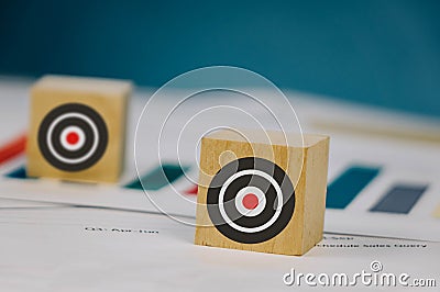 a wooden cubin lies on a table with files with a picture of a target Stock Photo