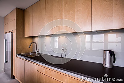 Wooden cupboards and black worktop Stock Photo