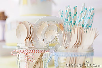 Wooden cutlery and paper straws in jam jars tied with kitchen twine Stock Photo