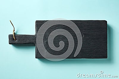 Wooden cutting board on blue background, from above Stock Photo