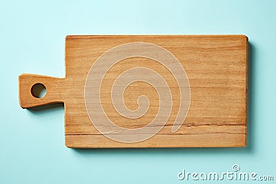 Wooden cutting board on blue background, from above Stock Photo