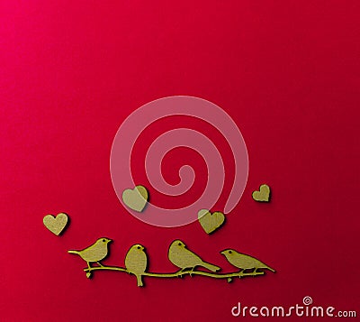 Wooden decoration flock of enamored birds sitting on a branch and wooden hearts around birds on a red background. Copy space. Stock Photo