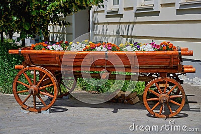 Wooden decorative carriage with flowers. Street decoration, a wagon with flowers Stock Photo