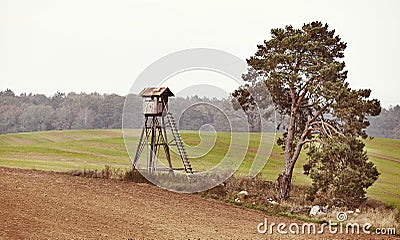 Wooden deer hunting pulpit on a field in autumn Stock Photo