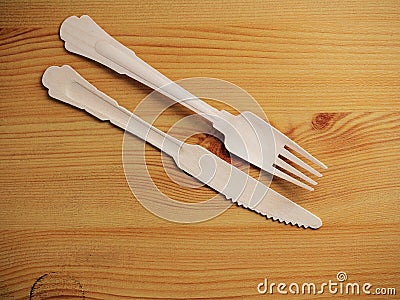 Wooden degradable fork and knife on a light wood table surface, Concept ecology and recycle issue Stock Photo