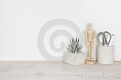 Wooden desktop with flower pot, human statuette and office supplies Stock Photo