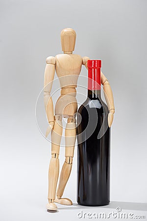 Wooden doll and bottle of red wine on grey background Stock Photo