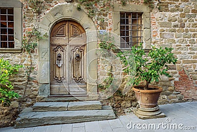 Wooden door in a small village of medieval origin. Volpaia, Tuscany, Italy Editorial Stock Photo