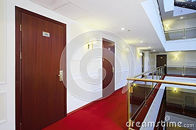 Wooden doors, red carpet on floor and handrails of balconies Stock Photo