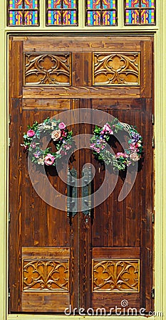 Wooden doors with two round floral wreaths Stock Photo