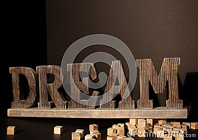 Wooden Dream large word with the wooden blocks around on the black background. Stock Photo