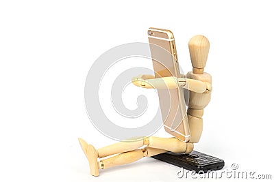 Wooden dummy grasping a new mobile smartphone in his arms and sitting on old phone mobile. Stock Photo