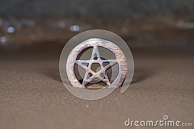 Wooden encircled Pentagram symbol on the beach at sunrise in front of the lake. Concept of Five elements: Stock Photo