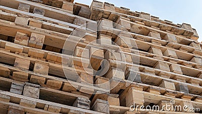 Wooden euro pallets for transfering goods to customers. Used wooden pallets in stack in the warehouse. Wooden pallet overlap Stock Photo