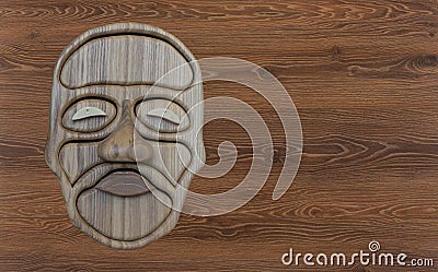 Wooden face made of natural oak on a wooden background Stock Photo