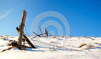 Wooden fence and broken barbed wire Stock Photo