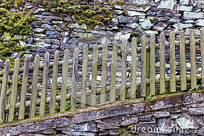 Wooden fence at a drystone wall Stock Photo