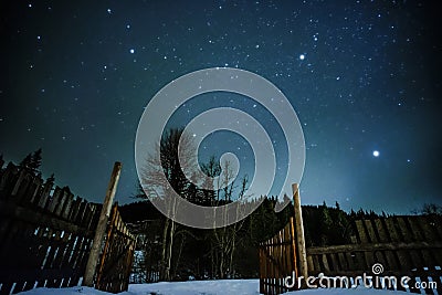 Wooden fence in mountains with starry sky above Stock Photo