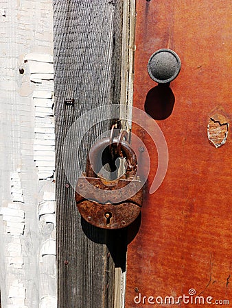 Wooden fence with a red door with a lock. Fence and gate cottages. Stock Photo