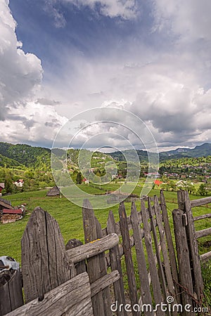 Wooden fence that serves as the border of a farm field in a valley near Stock Photo
