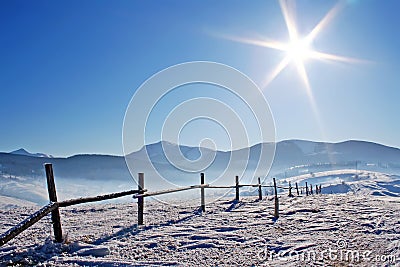 Wooden fence in snowcovered mountains Stock Photo