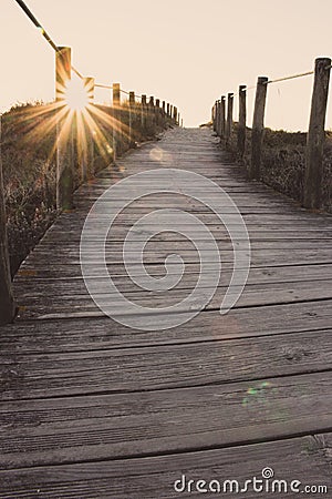 Wooden fence and walkway to beach faded. Empty path in sunlight. Walking concept. Camino de Santiago way. Stock Photo