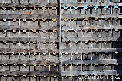 A wooden fencing made of old wine racks. The wooden enclosure with rows of round holes. Stock Photo