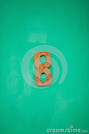 Wooden figure eight number on emerald wall Stock Photo