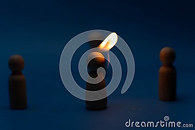 The wooden figure, isolated from the crowd with a fire, being chased away due to confusion and conflict with others. Concepts of Stock Photo