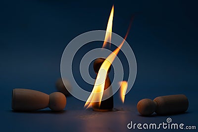 The wooden figure, isolated from the crowd with a fire, being chased away due to confusion and conflict with others. Concepts of Stock Photo