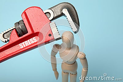 Wooden figure of man with clamped head in vice. Headache, stress, migraine Stock Photo