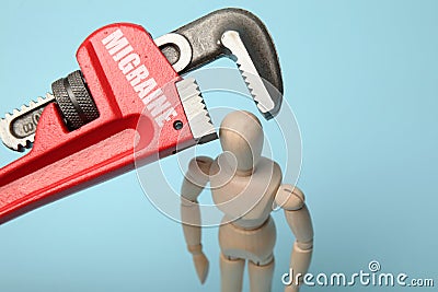 Wooden figure of man with his head clamped in vice with inscription migraine. Pain, stress, headache Stock Photo