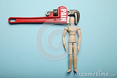 Wooden figure of man with his head clamped in vice with inscription Pain. Headache, stress, migraine Stock Photo