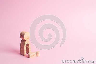 A wooden figure of a woman with a void from which a child fell. The concept of the loss of a child, abortion of pregnancy Stock Photo