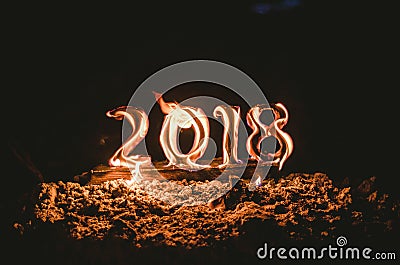 Wooden figures 2018 are burned in a flame. Conceptual photo end of the year. Stock Photo