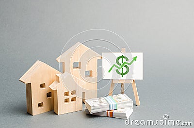 Wooden figures of houses and a poster with money. The concept of real estate value growth. Increase liquidity and attractiveness Stock Photo
