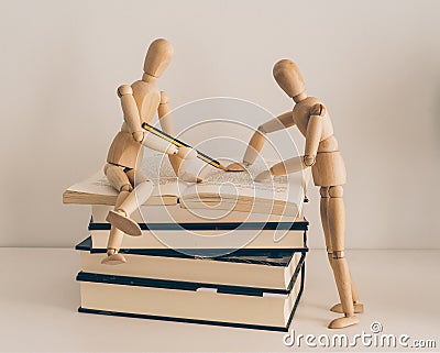 Wooden figures learning and teaching with books, culture and education Stock Photo