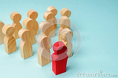 Wooden figures of people. The boss of the business team indicates the direction of movement to the goal. The crowd is following Stock Photo