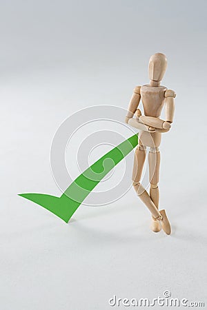 Wooden figurine with green check mark Stock Photo