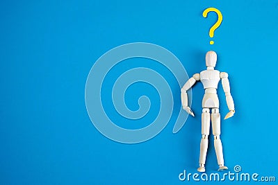 Wooden figurine of a man with question mark on a blue and pink background with clear space for text Stock Photo