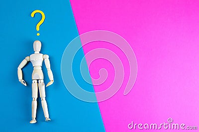 Wooden figurine of a man with question mark on a blue and pink background with clear space for text Stock Photo