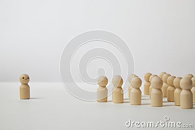 Wooden figurines with a leader and a group with partial focus. The confrontation between the head and the employees Stock Photo