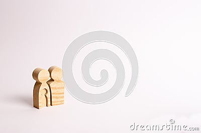 Wooden figurines of parents stand on a white background. Concept of pregnancy, young family. Planning for the family Stock Photo