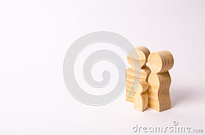 Wooden figurines of a young family on a white background. Concept of a young strong and healthy married couple. Stock Photo